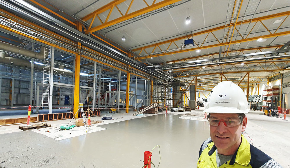 constructions in new production hall, portrait of man, white helmet