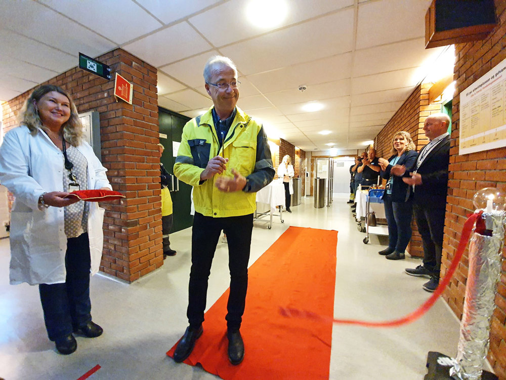 man cutting ribbon, official opening