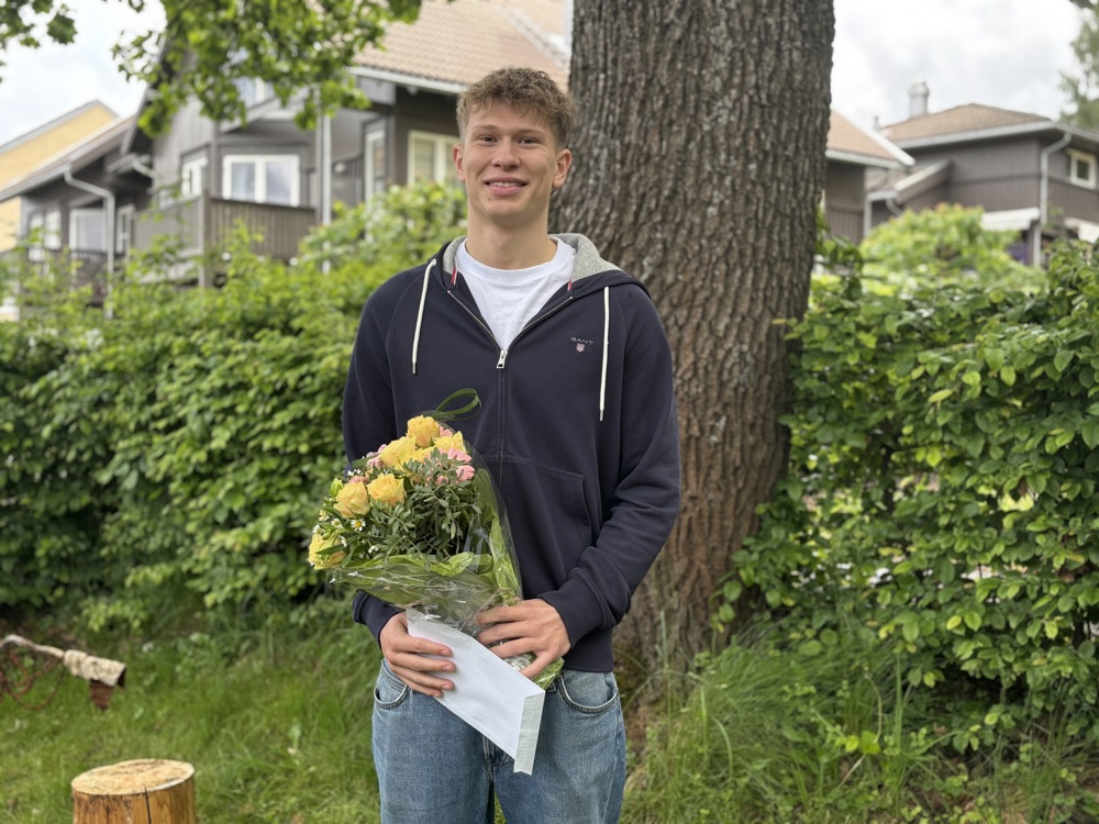 ung mann med blomsterbukett og hvit konvolutt