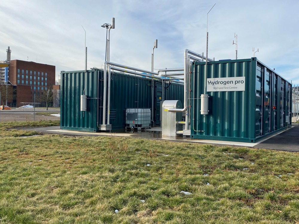 two containers, pipes, green grass around the area