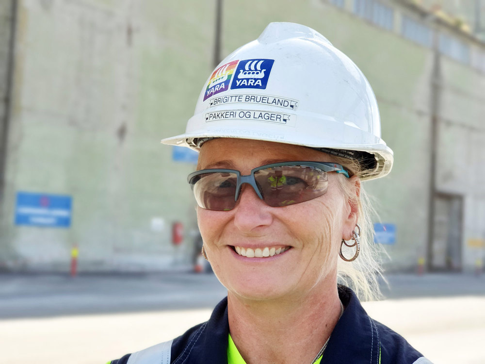 woman with dark glasses and white helmet outside in the industrial park