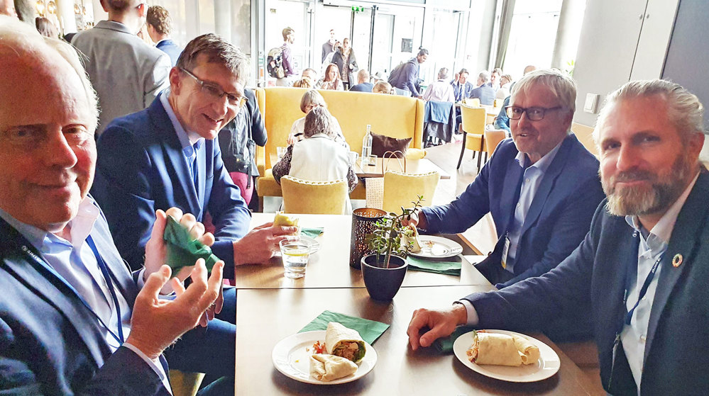 four men at a table eating lunch