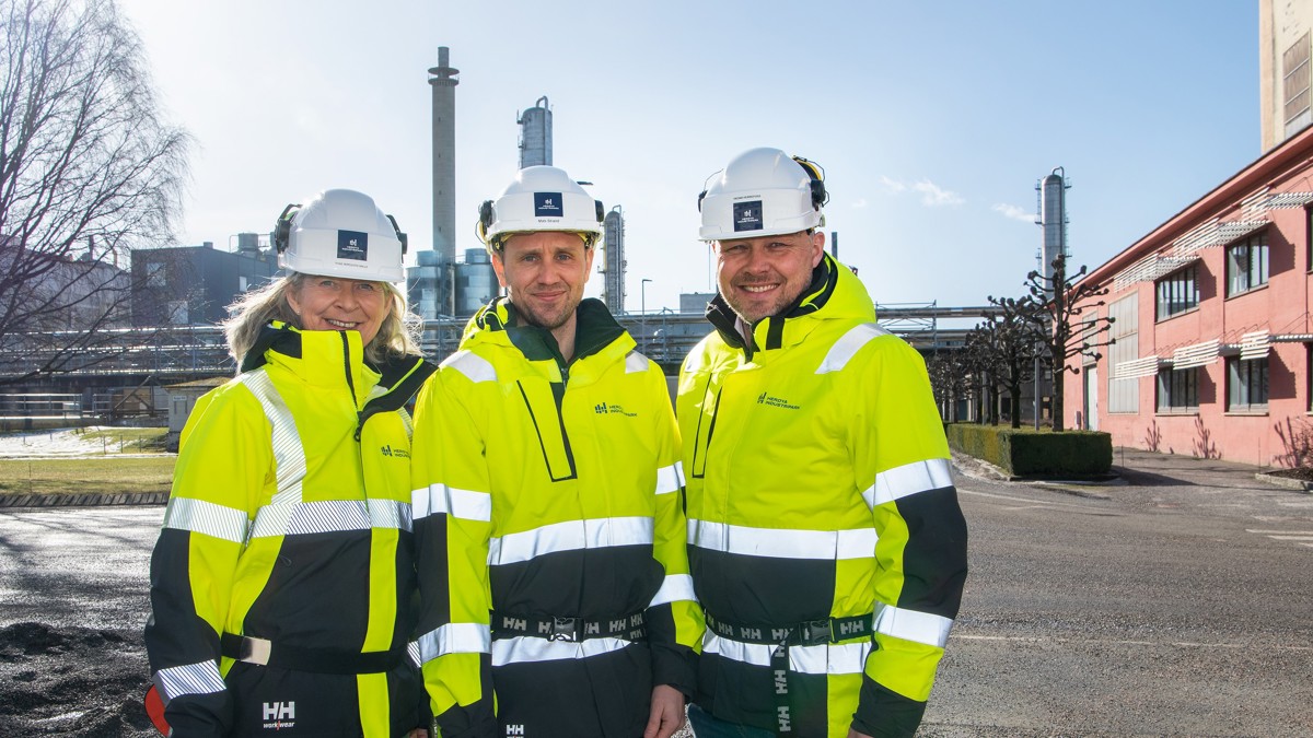 three persons, posing, helmet and yellow jackets, industrial park, winter