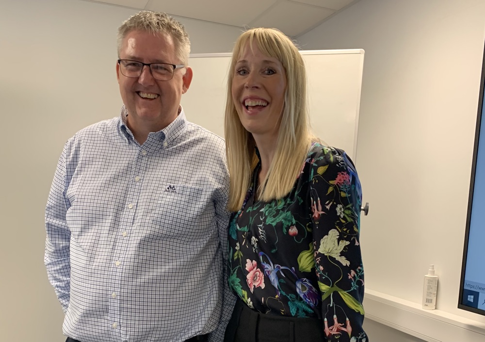 man and woman standing in a meeting room