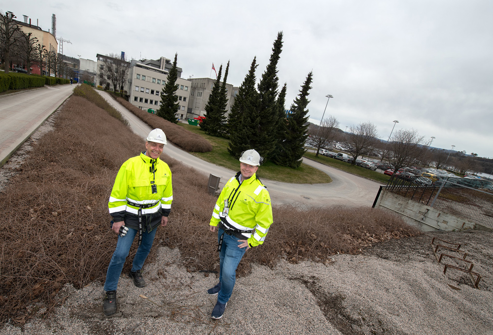 to menn i gule jakker ute i industripark