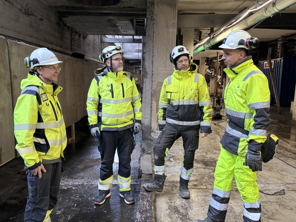 4 menn i samtale, kjeller, betongbygg