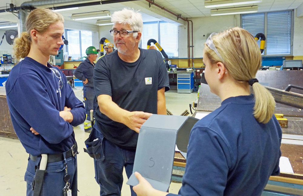 Senior and two apprentices talking in a workshop