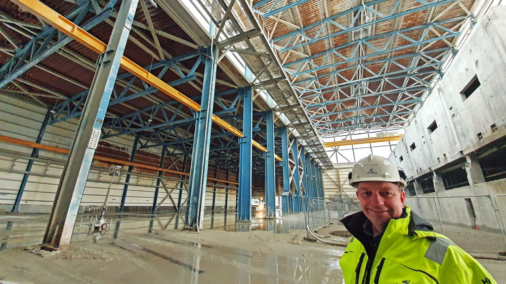man standing in a large white empty production hall