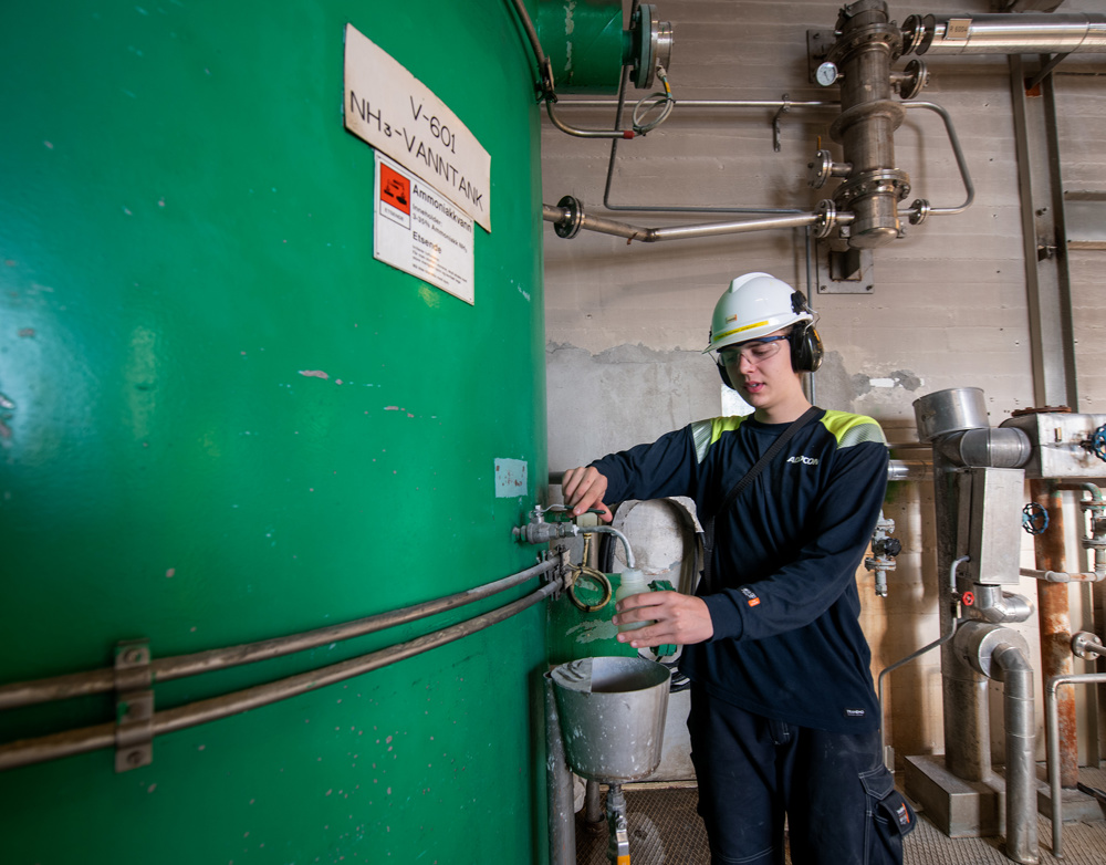 apprentice, taking samples for testing, green big tank